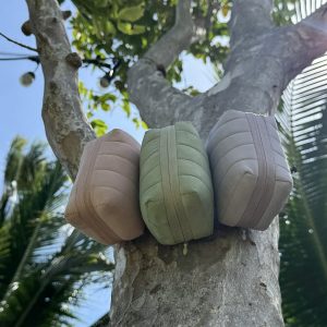 Three allour pouches resting on a tree trunk